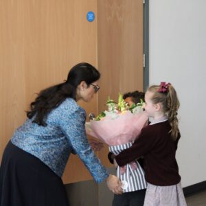Two Lakeland Primary School pupils present flowers to Priti Patel MP