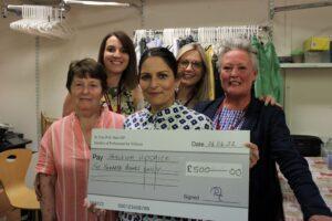 Priti Patel MP presents a cheque for £500 as her personal donation to Farleigh Hospice to Shop Manager Danielle Gadd and her team. From left: Ann, Sarah, Fay and Danielle
